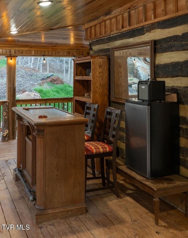 interior space featuring stainless steel refrigerator, hardwood / wood-style floors, and wood ceiling