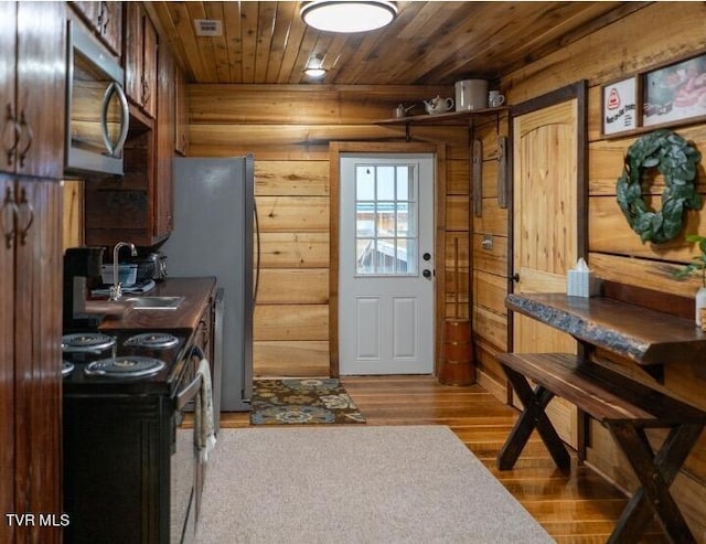 kitchen featuring black / electric stove, sink, hardwood / wood-style flooring, and wood ceiling