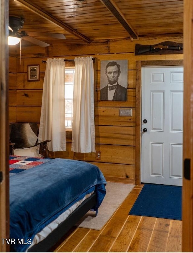 bedroom featuring wood walls, ceiling fan, hardwood / wood-style flooring, and wood ceiling