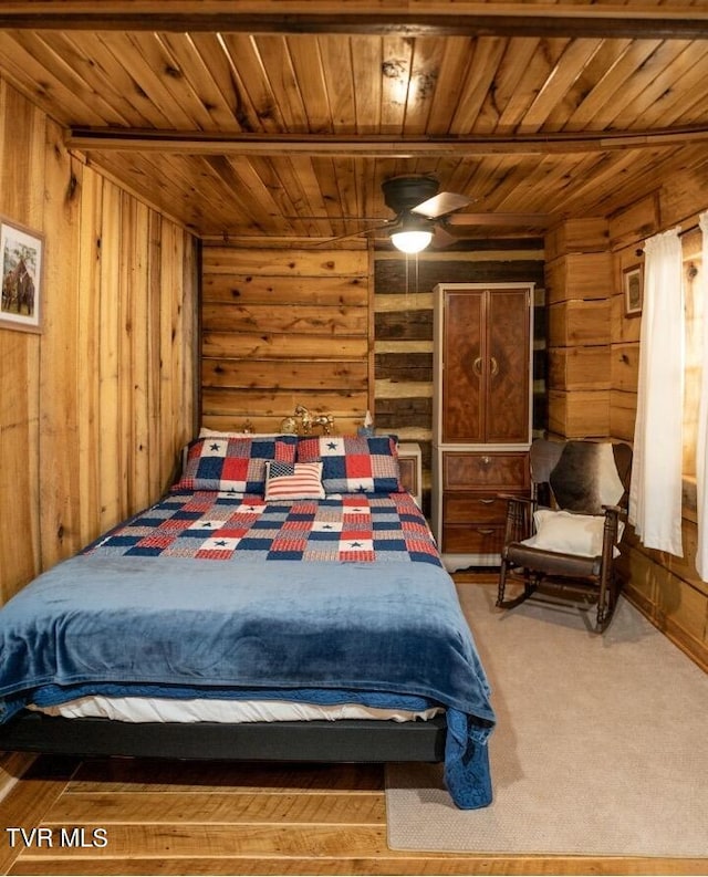 bedroom with wooden ceiling, ceiling fan, wood walls, and hardwood / wood-style floors