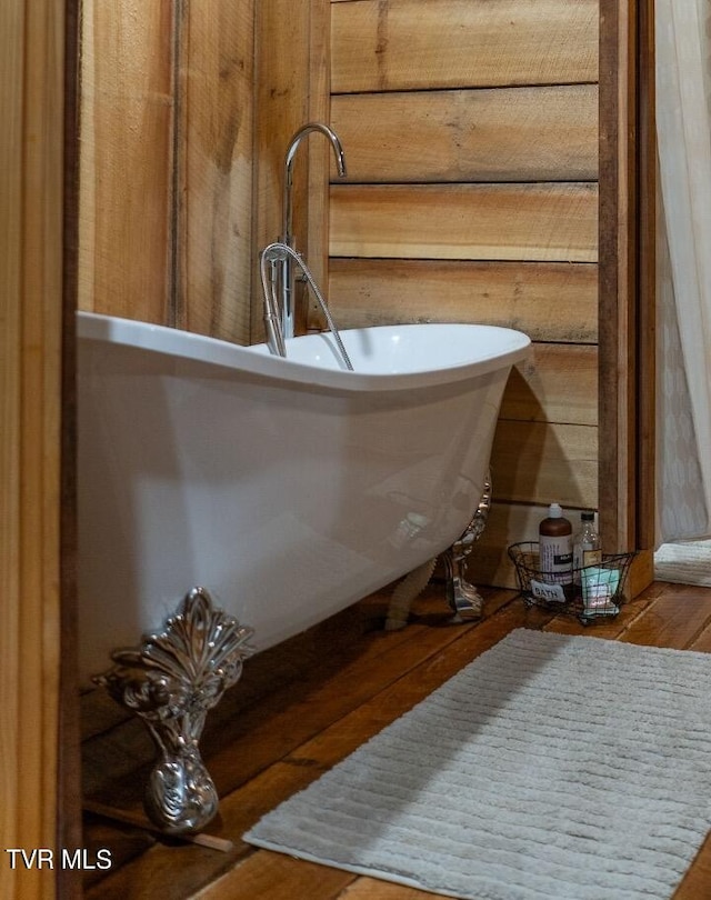 room details featuring wood-type flooring and a tub