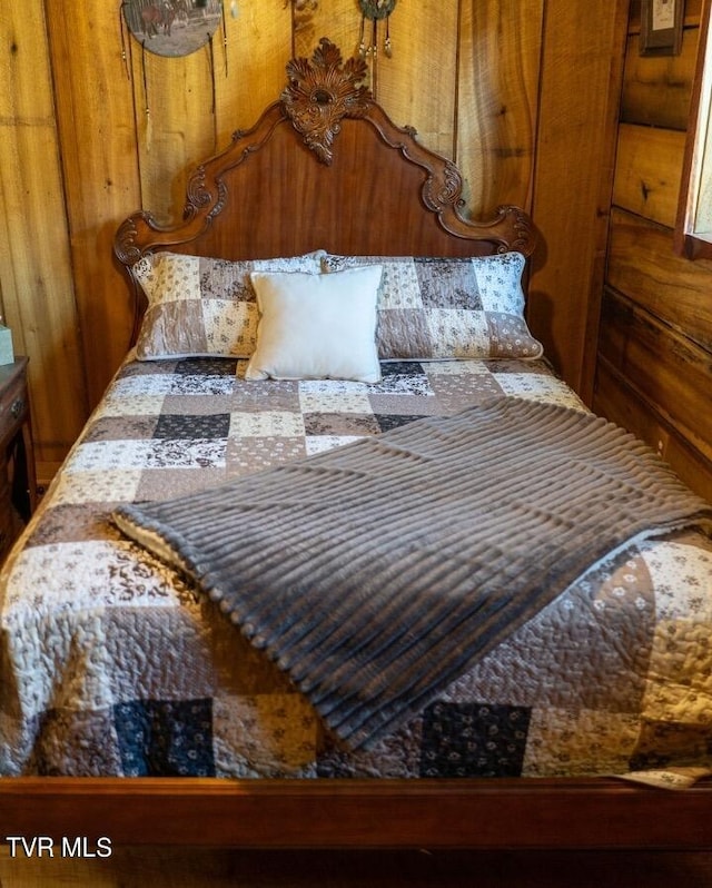 bedroom featuring wood walls