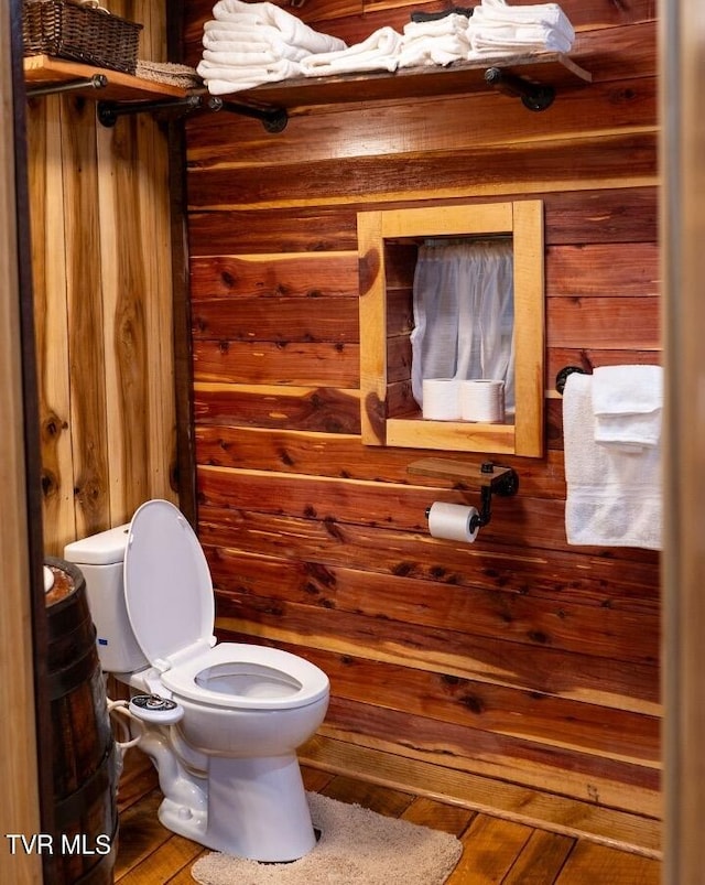 bathroom with wood walls and toilet