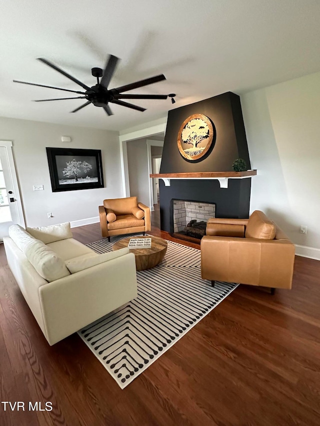 living room featuring ceiling fan and dark wood-type flooring