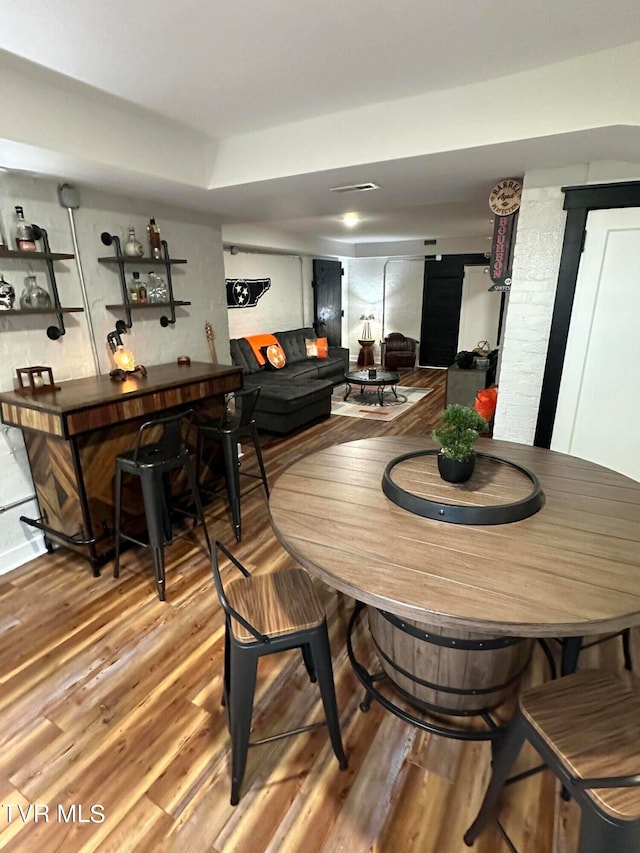 dining room featuring bar area and wood-type flooring