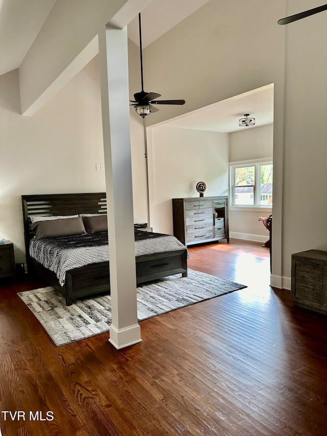 bedroom featuring ceiling fan, dark wood-type flooring, and lofted ceiling