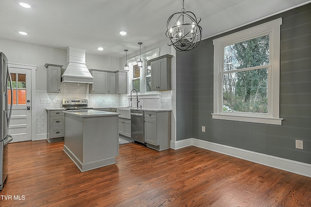 kitchen featuring gray cabinets, a kitchen island, hanging light fixtures, and custom exhaust hood