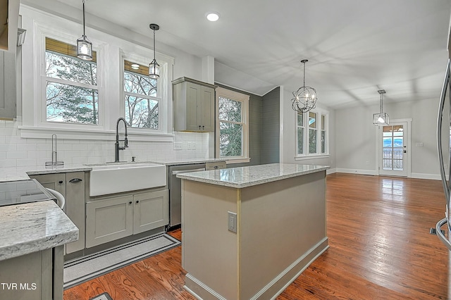 kitchen featuring gray cabinetry, sink, hardwood / wood-style floors, a center island, and hanging light fixtures