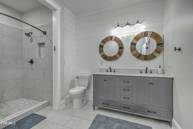 bathroom with toilet, vanity, and tiled shower