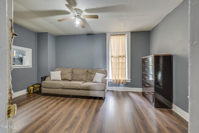 living room featuring ceiling fan and dark hardwood / wood-style flooring