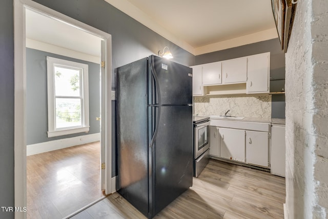 kitchen featuring black fridge, white cabinetry, stove, and light hardwood / wood-style floors