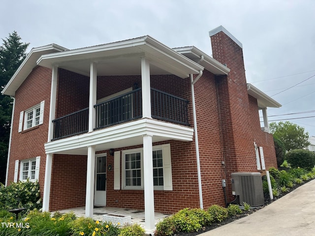 view of side of home featuring central AC unit and a balcony