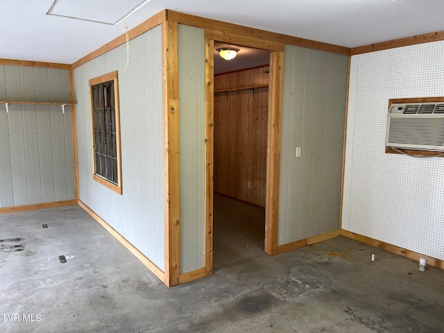 interior space featuring a wall mounted AC, wood walls, and concrete flooring