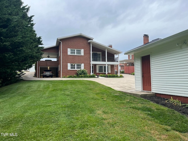 rear view of property featuring a carport and a yard