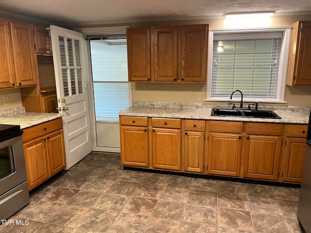 kitchen with sink, stove, dark tile flooring, and light stone counters