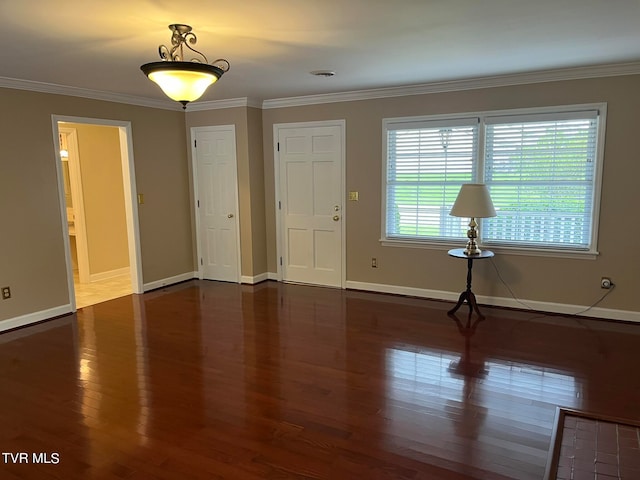 empty room featuring a wealth of natural light, ornamental molding, and dark hardwood / wood-style flooring