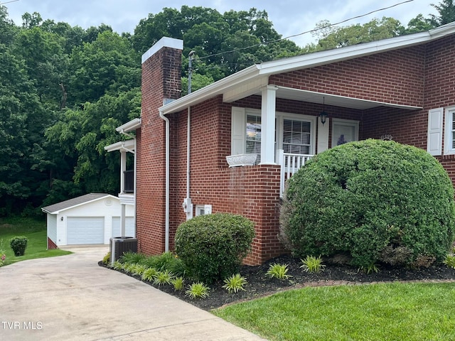 view of side of home featuring a garage, an outdoor structure, and central air condition unit