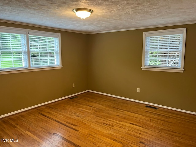 unfurnished room with wood-type flooring, a textured ceiling, and crown molding