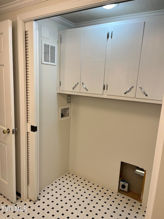 laundry room with cabinets, crown molding, and light tile floors