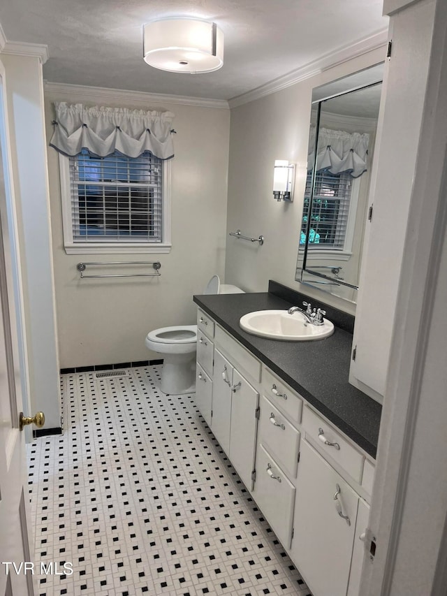 bathroom with tile flooring, crown molding, toilet, and vanity