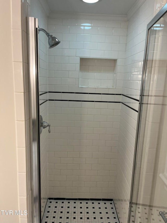 bathroom with crown molding and a shower with door