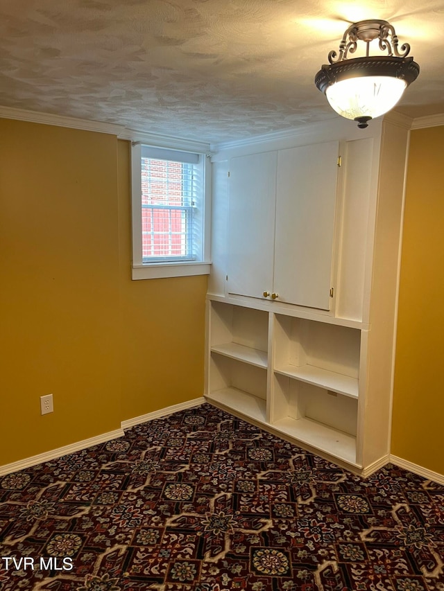 unfurnished room with ornamental molding and a textured ceiling