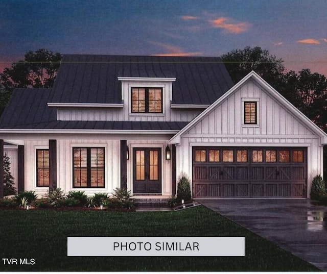 view of front of property featuring a garage, concrete driveway, metal roof, a standing seam roof, and french doors