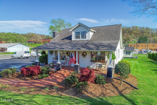 view of front of property with a front lawn, a garage, and covered porch