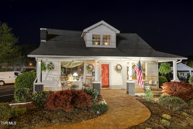 new england style home featuring a porch