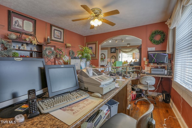 interior space featuring hardwood / wood-style floors, plenty of natural light, ceiling fan, and a textured ceiling