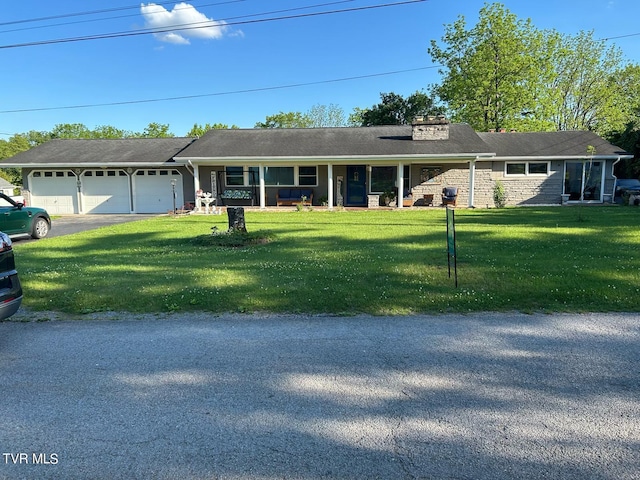 ranch-style house with a garage, covered porch, and a front lawn