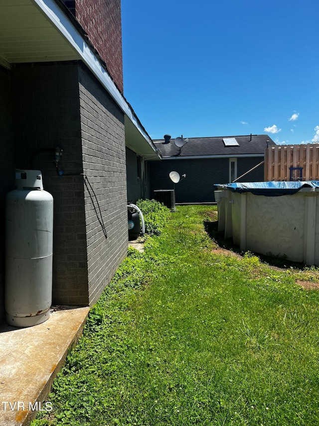 view of yard featuring central AC and a covered pool