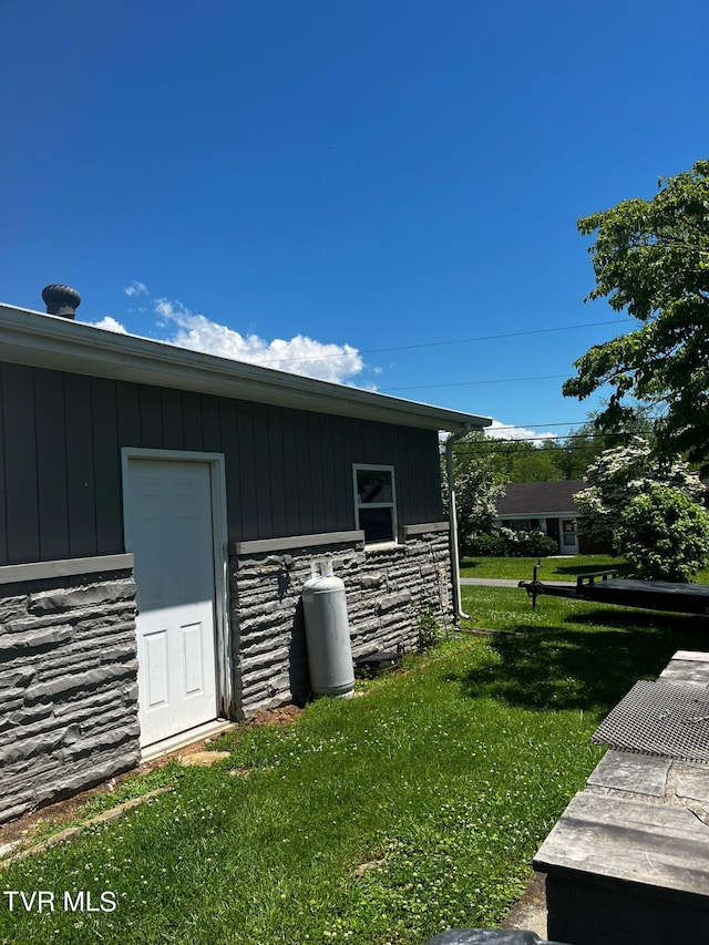 view of side of home with a yard