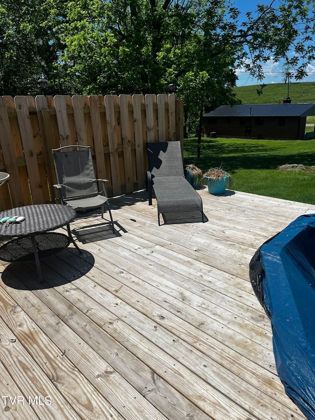 wooden terrace featuring a yard