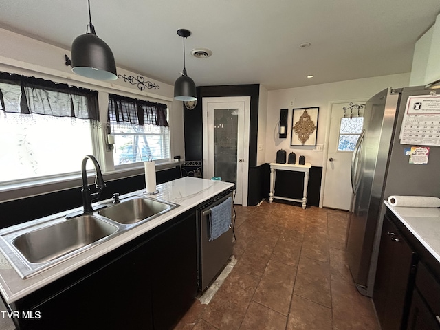 kitchen featuring pendant lighting, sink, stainless steel appliances, and a center island