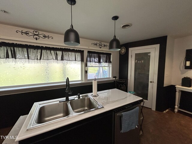 kitchen featuring hanging light fixtures, dishwasher, and sink