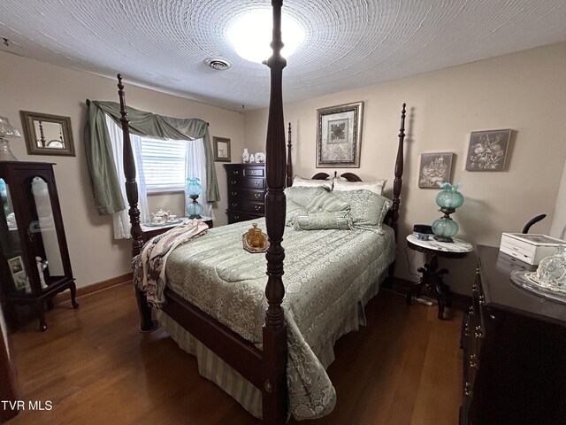 bedroom with dark wood-type flooring and a textured ceiling