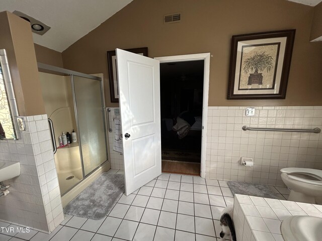 bathroom featuring a shower with shower door, tile patterned flooring, and tile walls