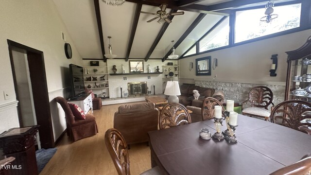 dining space with beam ceiling, high vaulted ceiling, ceiling fan, and light wood-type flooring