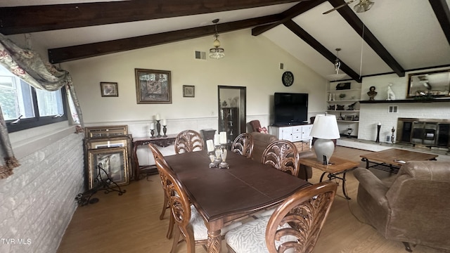 dining space with vaulted ceiling with beams and light hardwood / wood-style floors