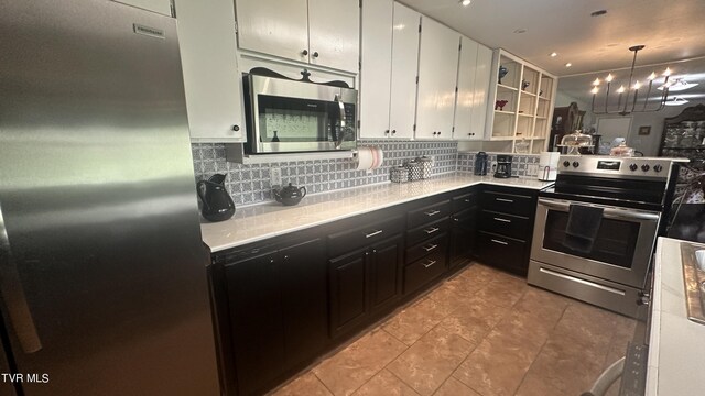 kitchen featuring light tile patterned flooring, white cabinetry, tasteful backsplash, appliances with stainless steel finishes, and pendant lighting