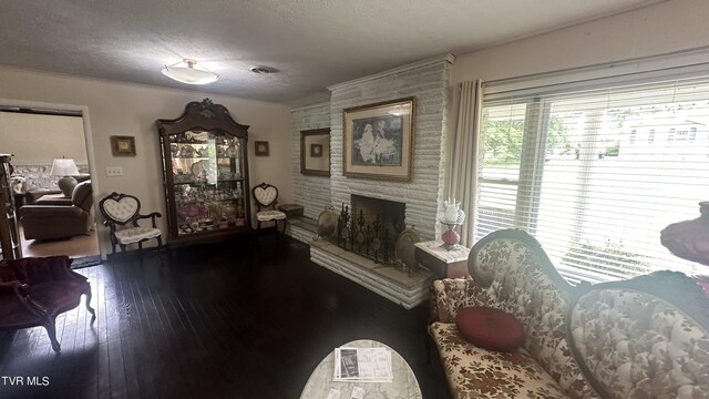 interior space with hardwood / wood-style floors, a large fireplace, and a textured ceiling