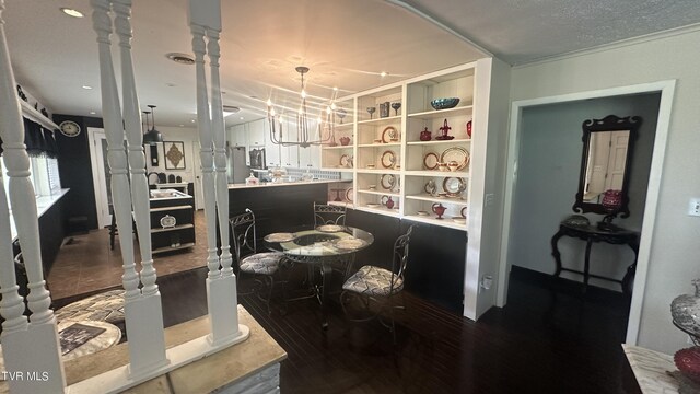 dining space with an inviting chandelier, hardwood / wood-style floors, built in features, and ornate columns