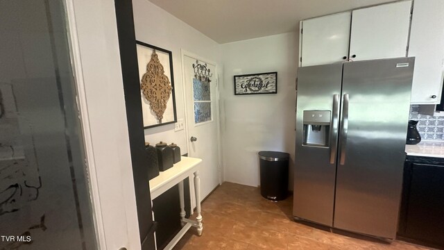 kitchen featuring white cabinetry and stainless steel fridge