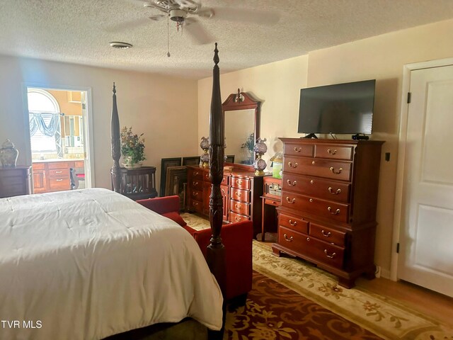 bedroom with ceiling fan, a textured ceiling, and ensuite bathroom