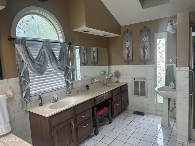 bathroom with lofted ceiling, heating unit, tile walls, and tile patterned floors