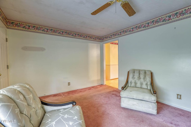 living area with carpet and ceiling fan