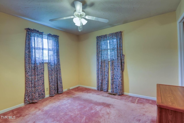 empty room with a textured ceiling, carpet floors, and ceiling fan