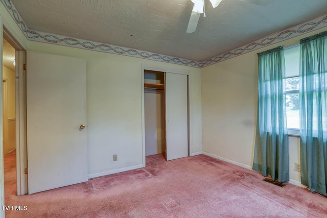 unfurnished bedroom featuring ceiling fan, a closet, carpet, and a textured ceiling