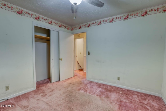 unfurnished bedroom with ceiling fan, a closet, light colored carpet, and a textured ceiling